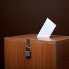 A locked ballot box with a ballot in the top