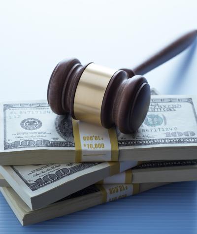 A gavel resting on top of a stack of money.