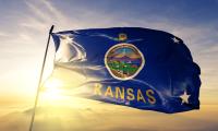 The state flag of Kansas with a sunburst in the background